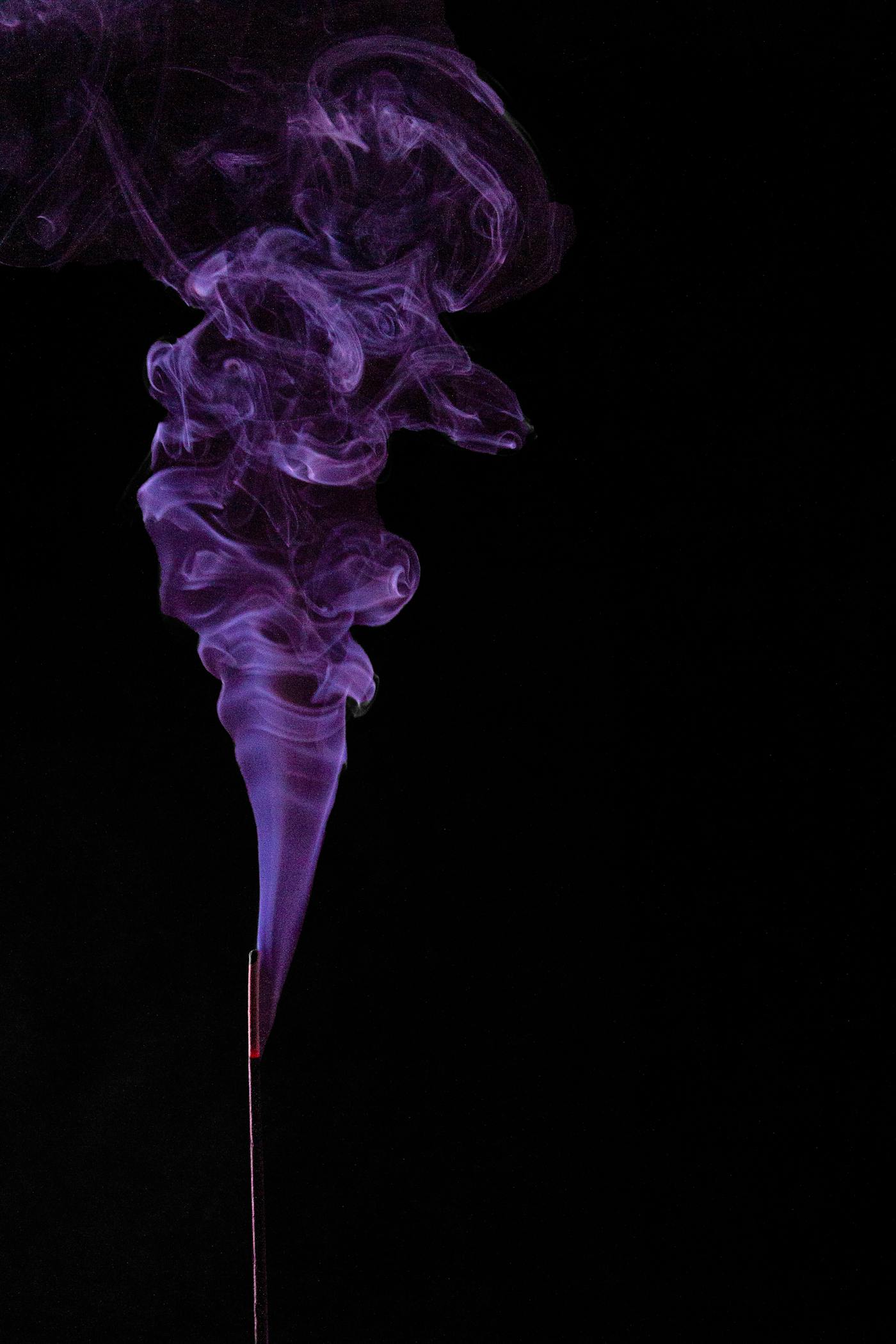 Encens violet qui monte sur fond noir